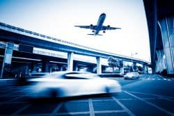 Blurred Street Scene In City With A Plane Flying Over